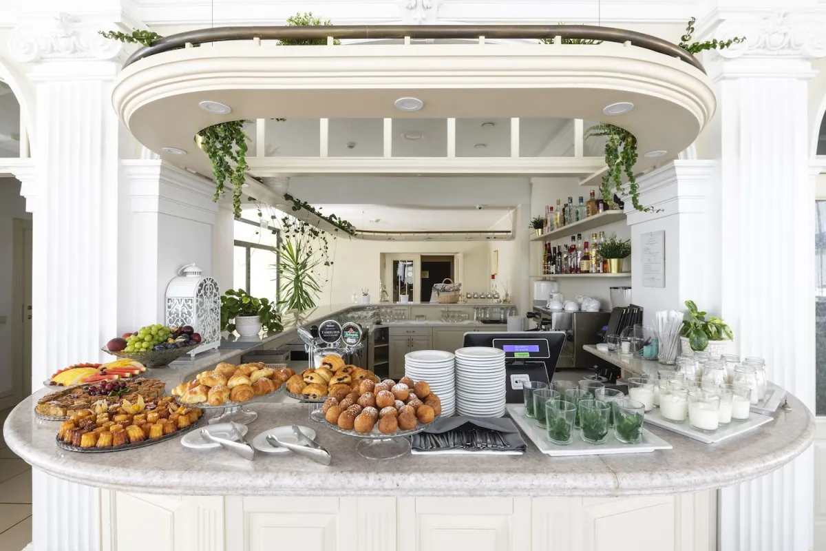 Buffet island with pastries, fruit and a coffee station under a white canopy
