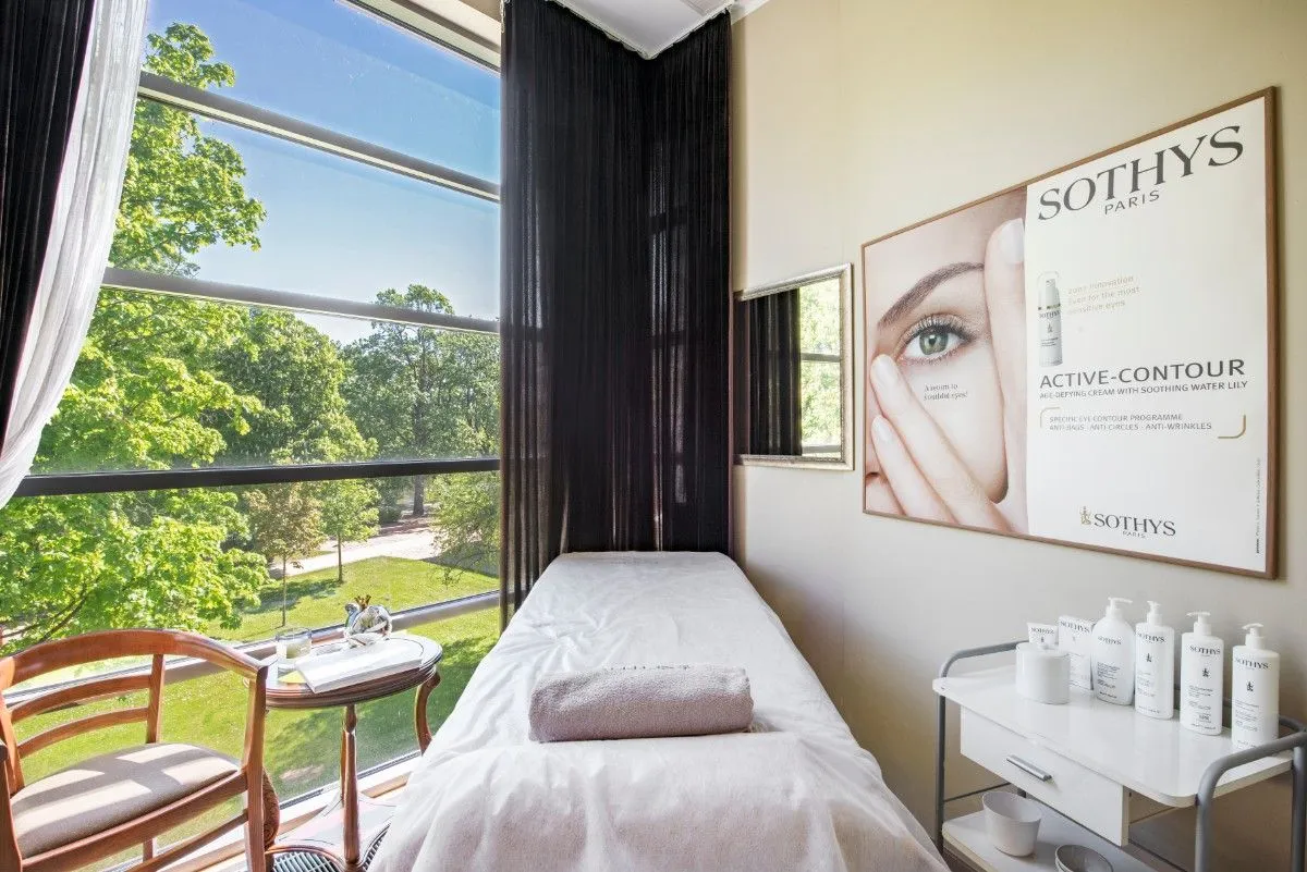 Beauty treatment room with a couch beside a window onto the park