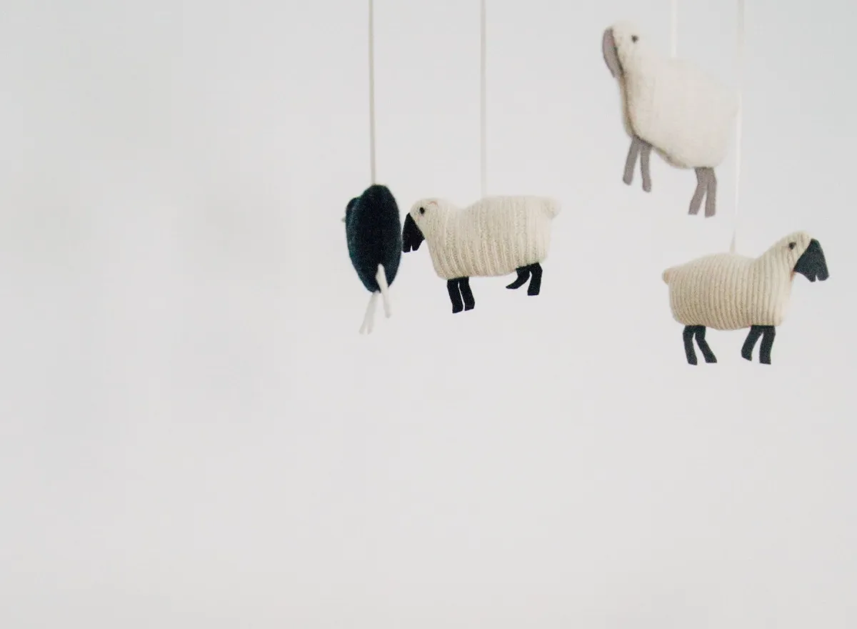 Knitted toy sheep hanging as a nursery mobile