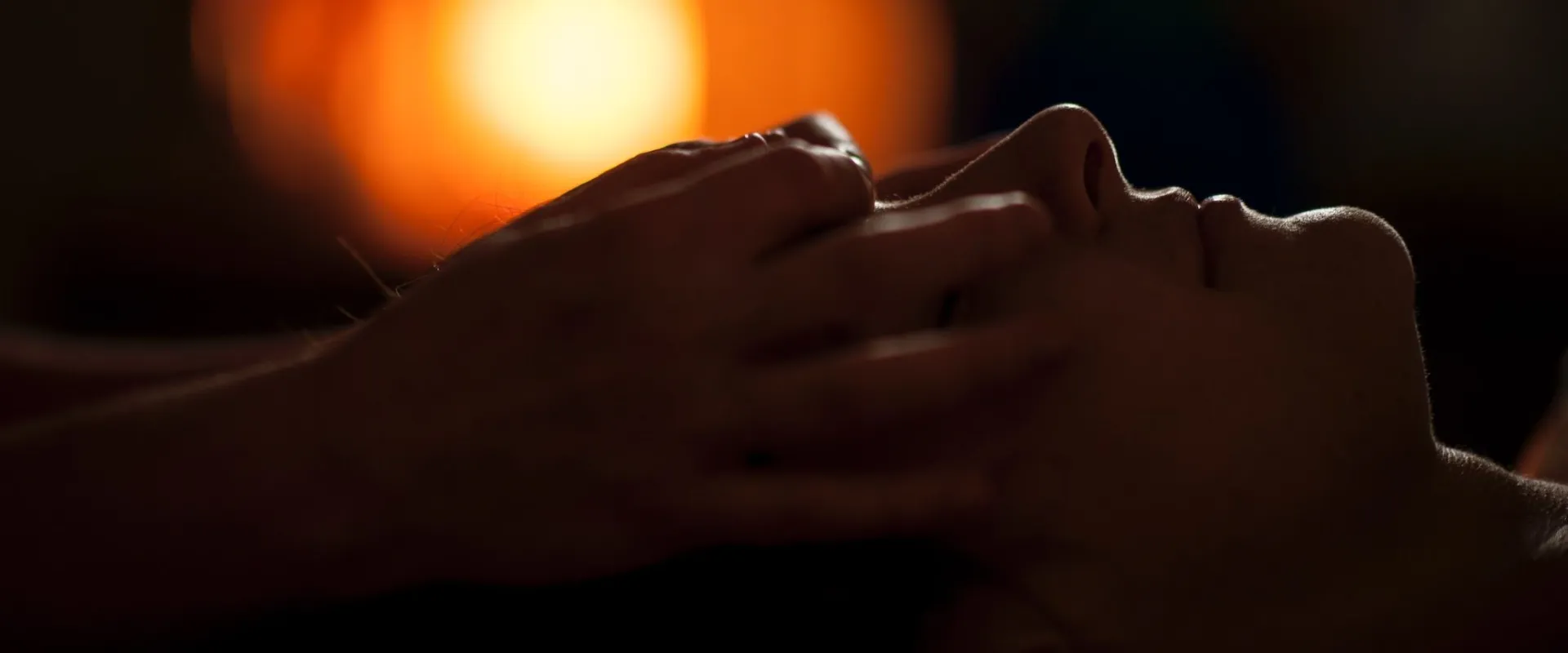 Therapist giving a head massage by candlelight