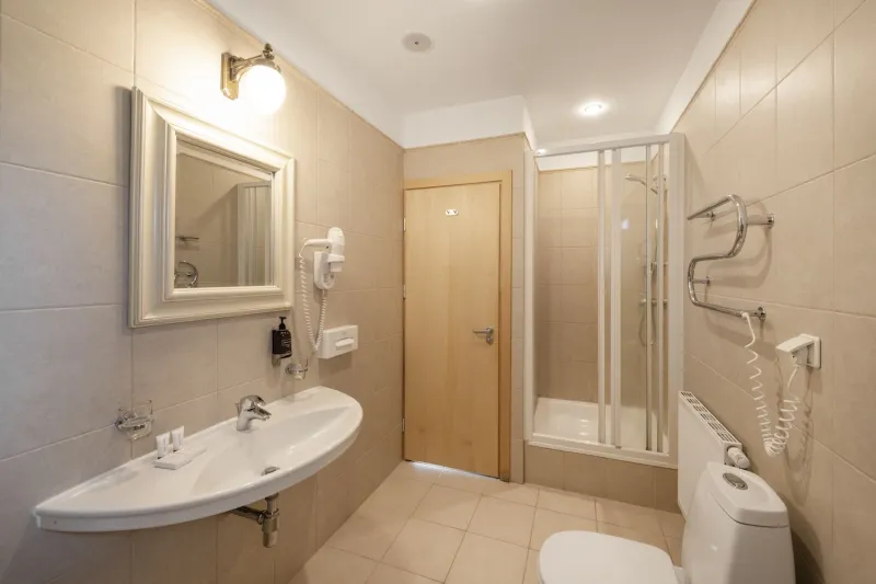 Bathroom with a glass shower cabin, wall-mounted basin and a large framed mirror