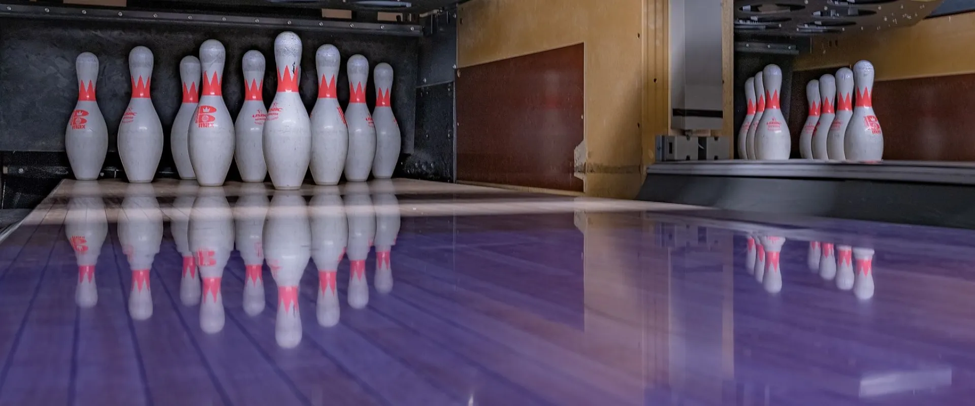 Bowling pins standing at the end of a polished lane