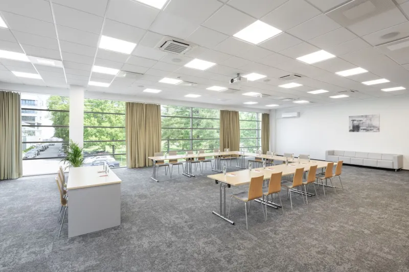 Meeting room with long tables and windows onto the surrounding trees