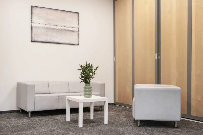 Waiting area with a white sofa, low table and armchair