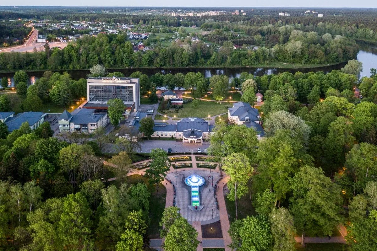 Aerial view of the hotel, park fountain and river at dusk