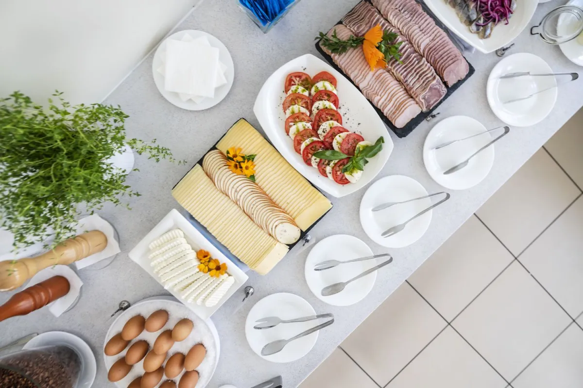 Buffet counter laid with cured meats, caprese, pastries and eggs